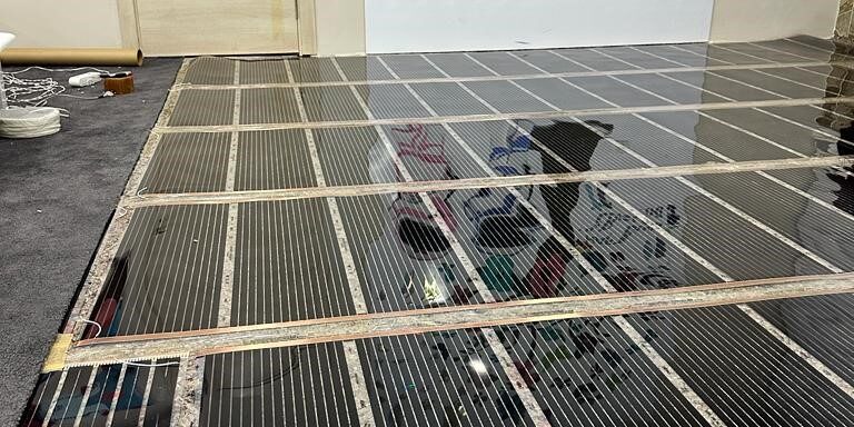 Carbon film heaters controlled by a thermostat
